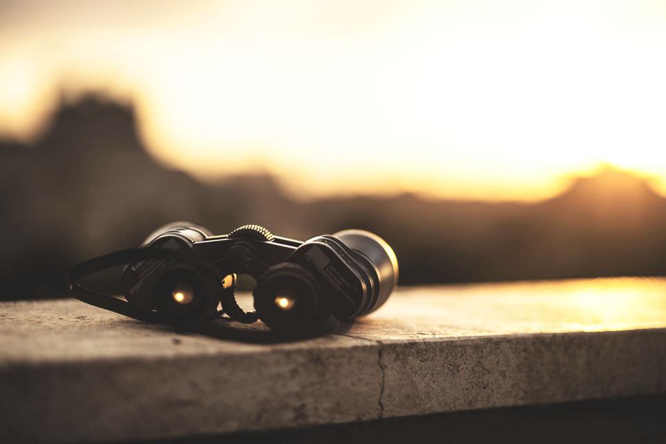 binoculars on a granite shelf with a view of the sunrise