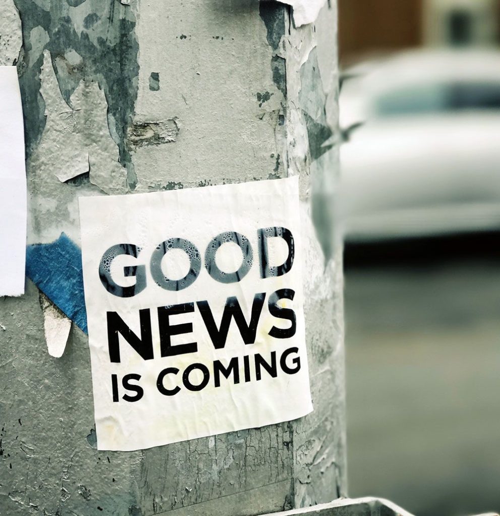 Good News is Coming sign posted on light post