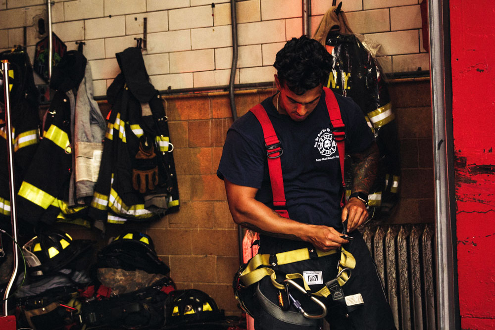 New York Firefighter in fire station putting on equipment