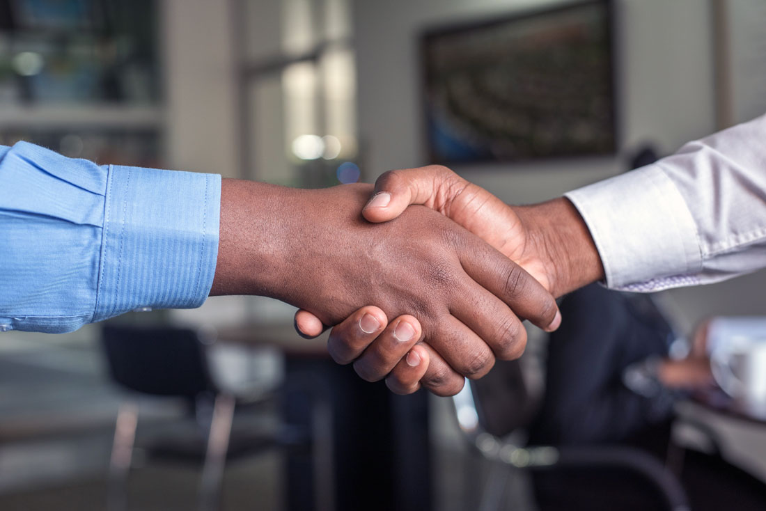 Two hands in a handshake, symbolizing agreement, congratulations, or relational warmth.